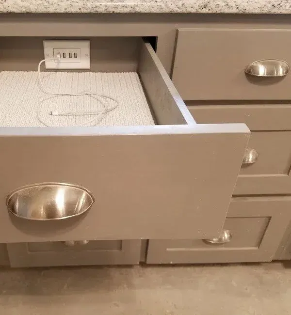 Cabinet drawer with integrated charging outlets